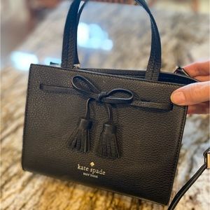 Kate Spade New York small black purse with pink interior.